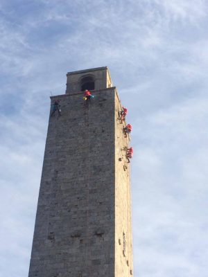 Operai vestiti da Babbo Natale ripuliscono le Torri di San Gimignano