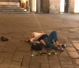 Amoreggiano distesi in mezzo a Piazza Tolomei