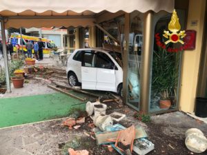 Scontro tra due auto: una sfonda l'ingresso di un hotel, l'altra si ribalta