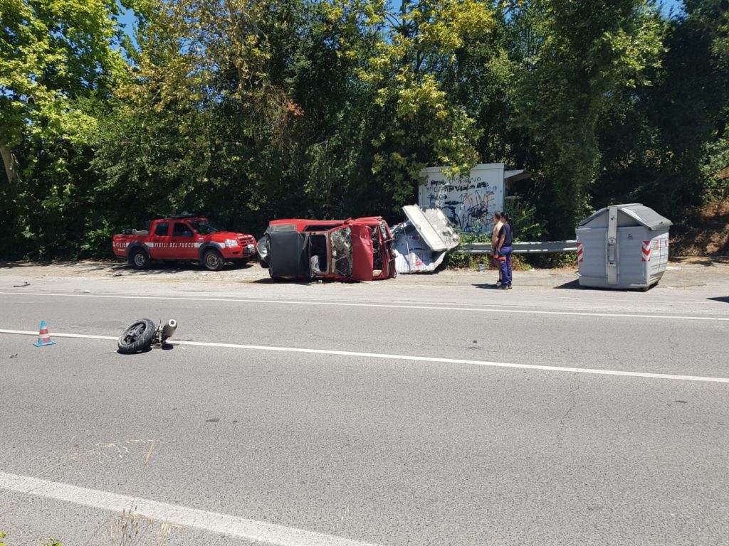 Schianto tra moto e un'auto che si ribalta e si abbatte sui cassonetti - FOTO E VIDEO