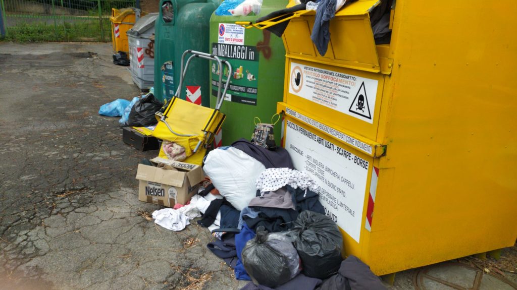 Cassonetto per la raccolta di vestiti trasformato in discarica