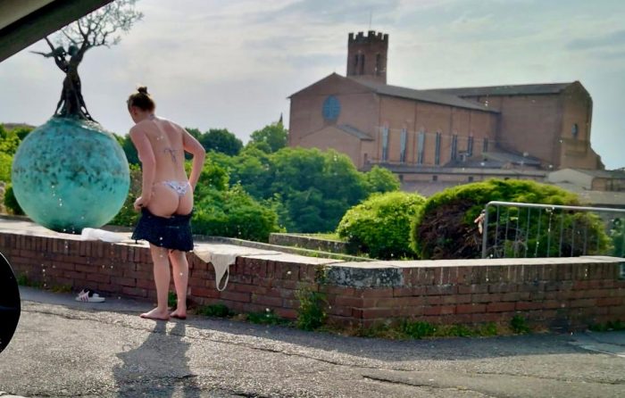 Siena: turista in costume prende il sole sulla terrazza di San Prospero