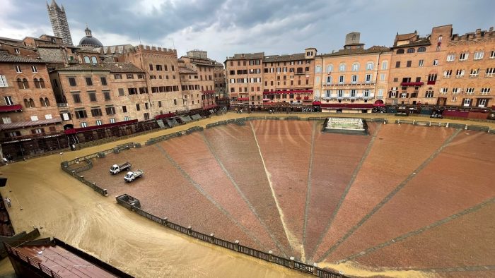 Pioggia su Piazza del Campo. I teli proteggono il tufo nell'entrone